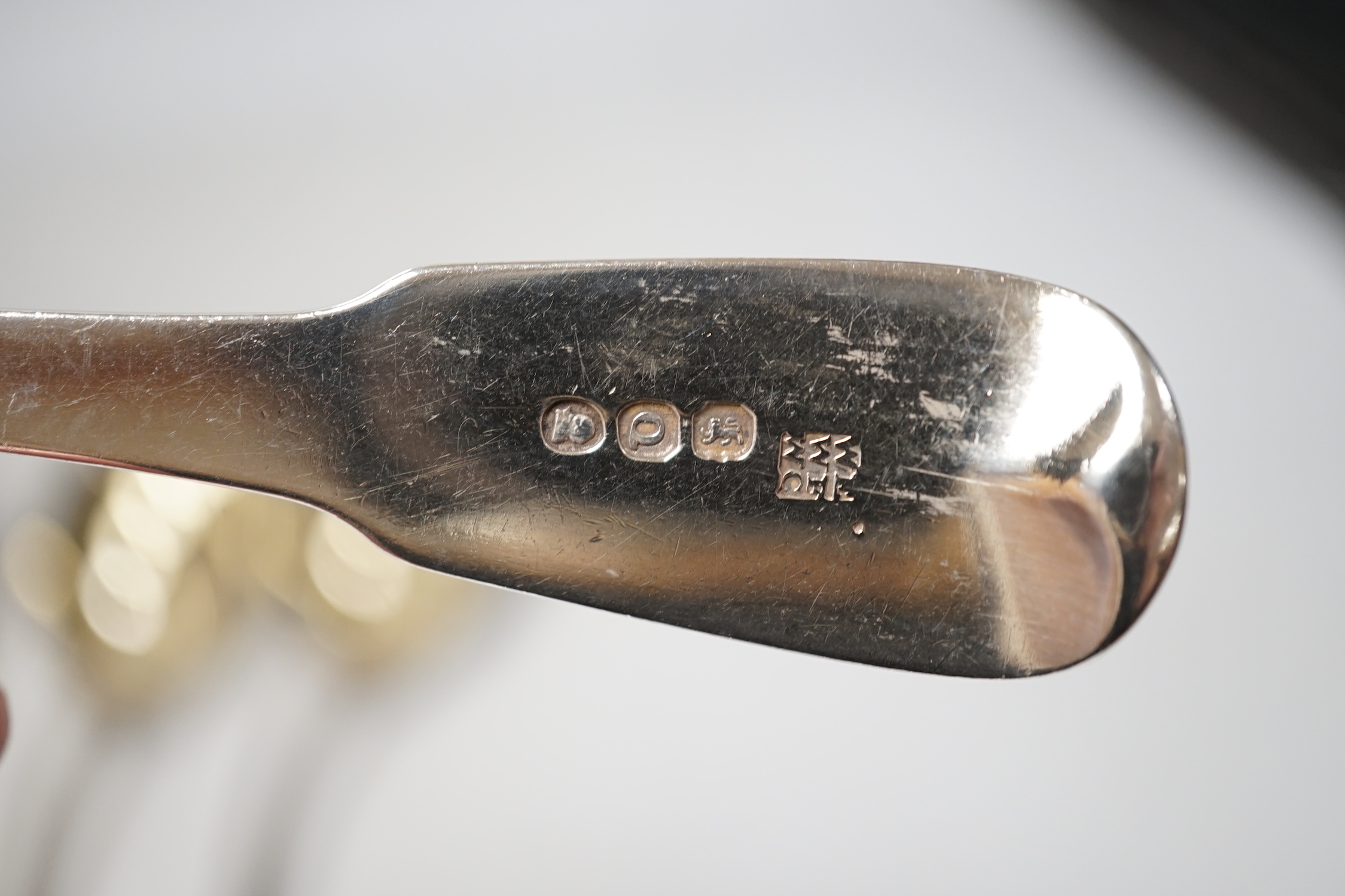 A pair of late Victorian silver serving spoons, with wavy foliate handles, Sheffield, 1897, 22.7cm, three other silver spoons and a pair of silver mounted dwarf candlesticks.
